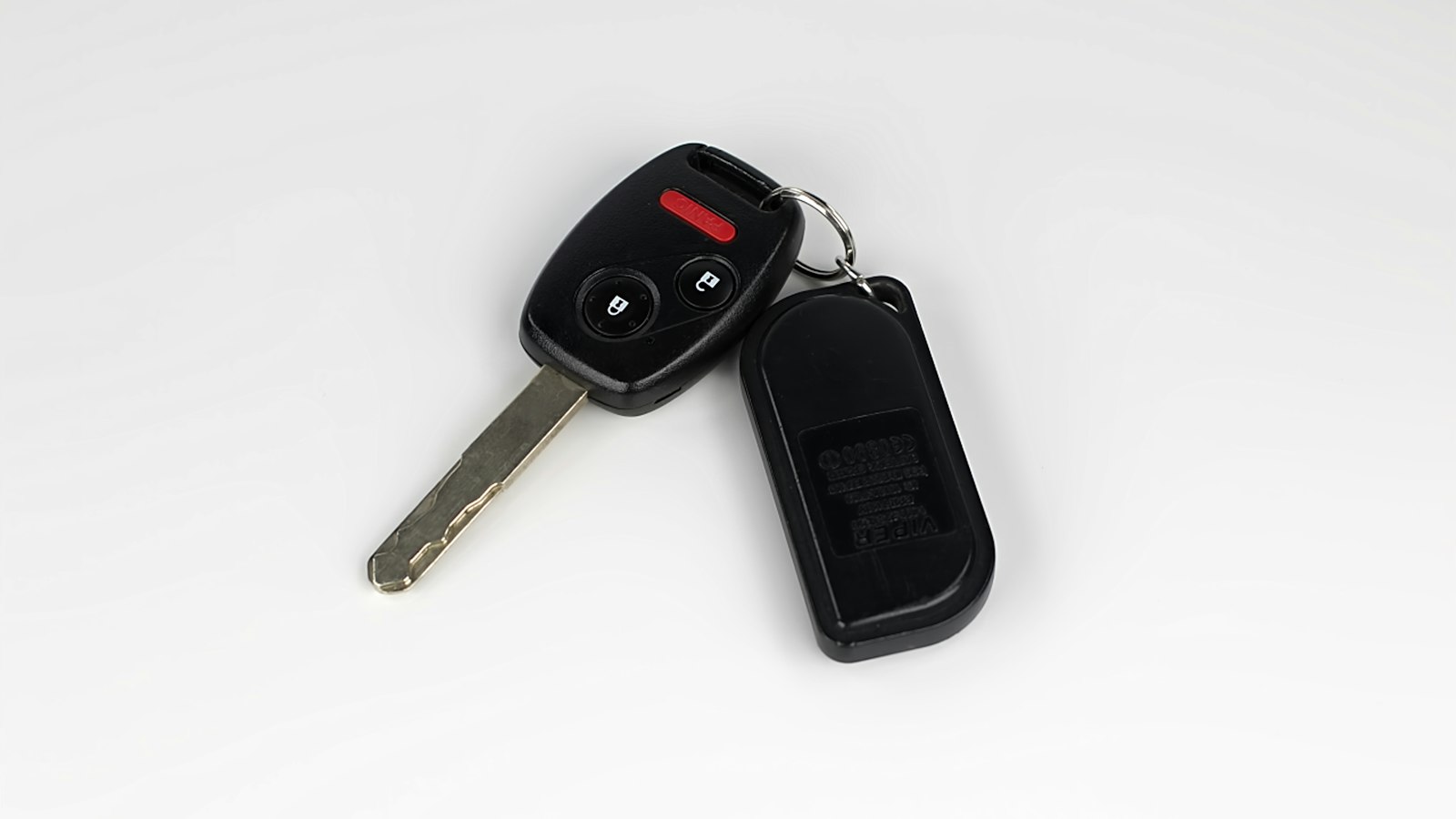 Chave de carro com controle remoto sobre fundo branco, para checar o histórico do veículo antes de comprar