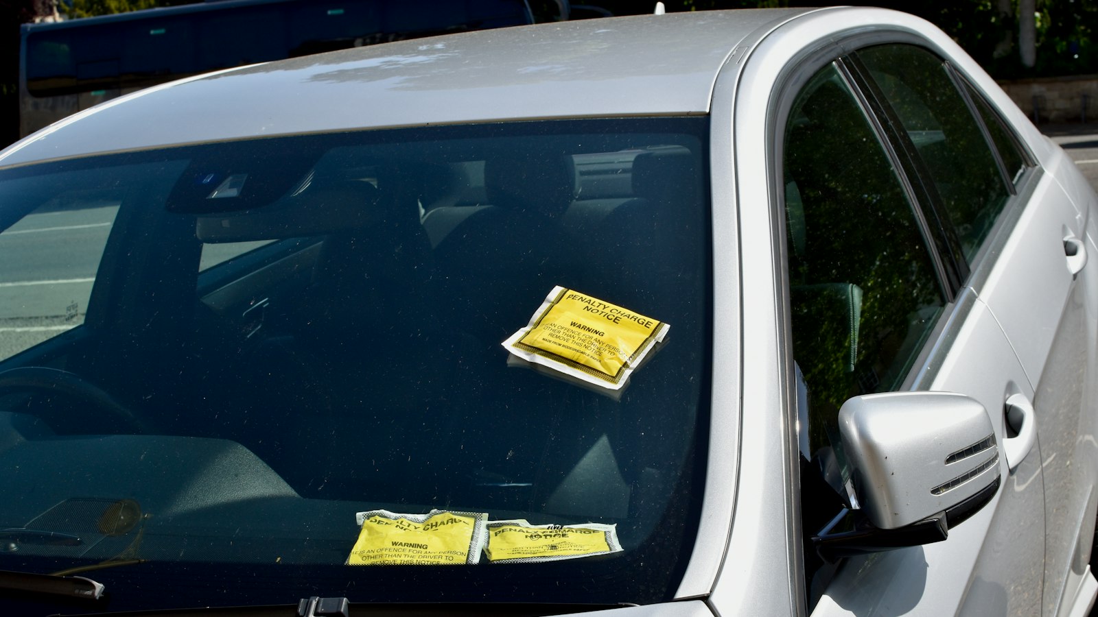 Carro com várias notificações de multa no para-brisa, multa RENAINF
