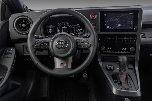 Toyota GR Yaris 2026: preço de R$ 354.990 e chegada Interior do Toyota GR Yaris 2026, painel digital com volante esportivo GR e costuras vermelhas