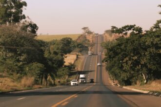 Rodovia brasileira cercada por arvores no Acre - consultar placa Detran AC