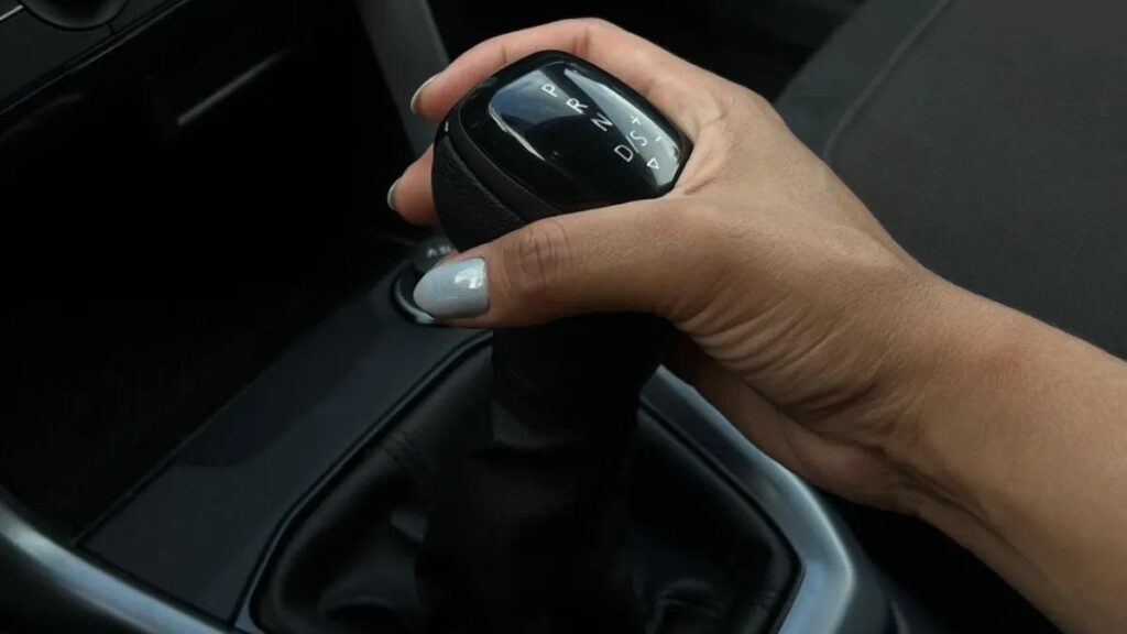 Mão segurando câmbio automático mostrando posições D, R, N e S