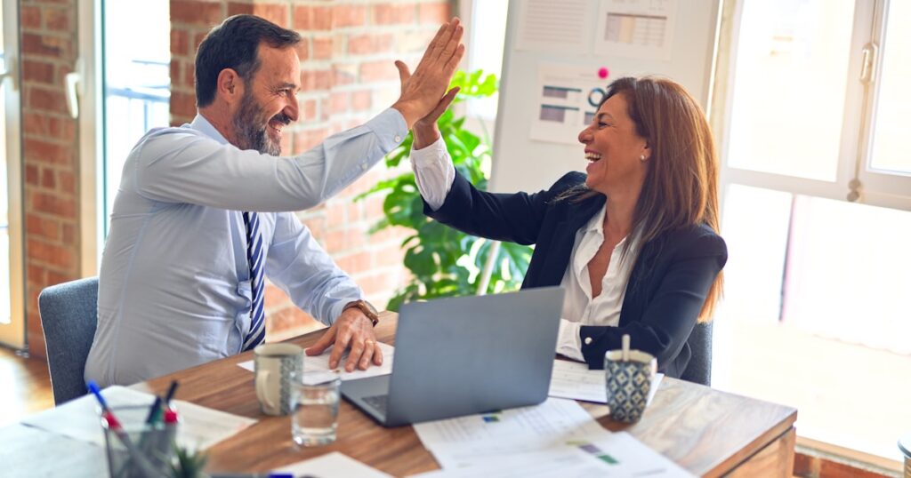 Mão segurando chave de carro com documentos de transferência de veículo ao fundo