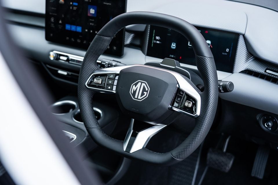 MG S5: preço, ficha técnica e vale a pena comprar o SUV elétrico britânico-chinês? Volante do MG S5 EV 2026 com logotipo MG e painel digital ao fundo