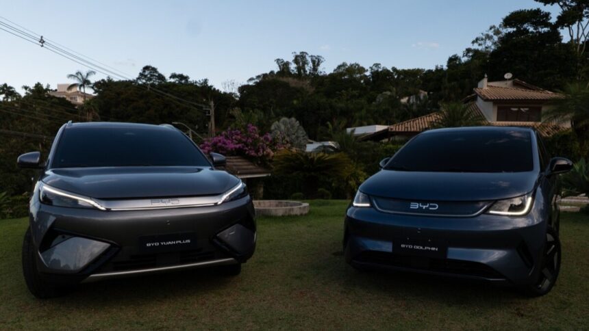 BYD Dolphin SE e Yuan Plus 2027 BYD Dolphin SE branco, vista frontal 3/4 em estúdio, destacando faróis, para-choque e rodas