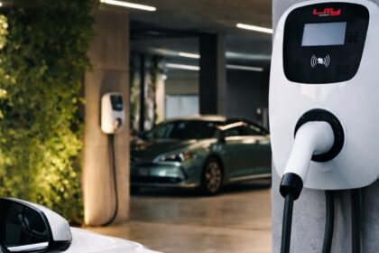 garagem residencial com wallbox instalado em vaga privativa, cabo conectado a um SUV elétrico, ambiente ventilado e organizado