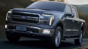 Recall da Ford F-150 e Maverick Ford F-150 branca rebocando trailer em vista traseira 3/4, destacando o engate e as luzes do reboque