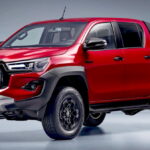 Toyota Hilux de entrada em tom prata, vista frontal 3/4 em estrada argentina, com foco na cabine simples e na caçamba