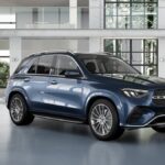 Mercedes-Benz GLE 450 d 4MATIC AMG Line 2026 azul escuro, vista frontal 3/4 em estúdio, rodas AMG de 21 polegadas em destaque