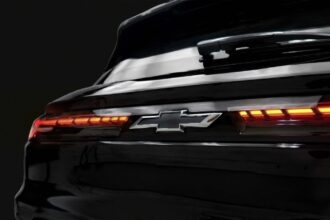 Chevrolet Onix 2026 branco, vista frontal 3/4 em rua urbana brasileira