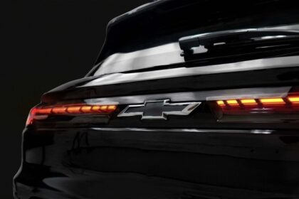 Chevrolet Onix 2026 branco, vista frontal 3/4 em rua urbana brasileira