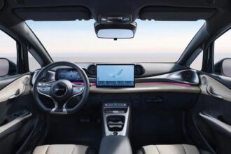 BYD Dolphin 2027 branco, vista frontal 3/4 em estúdio, com assinatura de LED e rodas aerodinâmicas