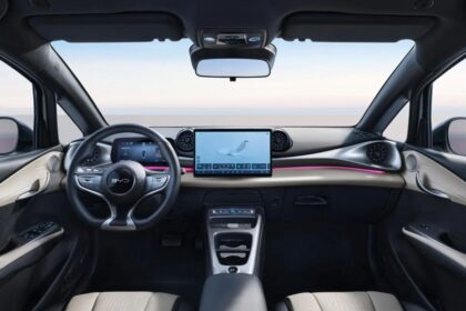 BYD Dolphin 2027 branco, vista frontal 3/4 em estúdio, com assinatura de LED e rodas aerodinâmicas