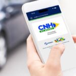 motorista consultando renovação da CNH no celular, com tela de serviço oficial do governo e ícone de cadeado