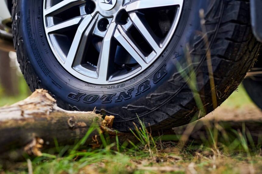 Pneu Dunlop fabricado no Brasil, vista frontal em estúdio, com destaque para a marcação Made in Brazil na lateral