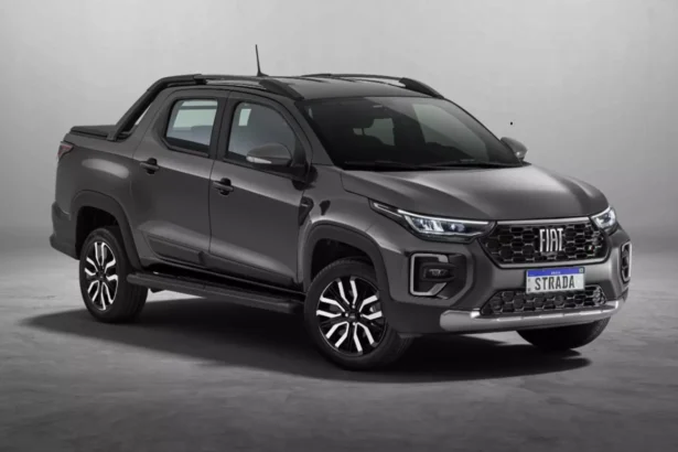 Fiat Strada 2026 branca, vista frontal 3/4 em rua urbana, com foco na grade e nos faróis