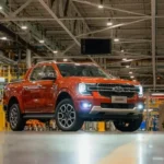 Ford Ranger V6 2026 em exposição na ExpoLondrina, vista frontal 3/4, pintura metálica, ambiente de feira agro