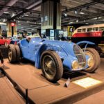 Retromobile 2026 em Paris, área principal da feira com carros clássicos expostos e público circulando