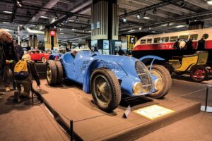 Retromobile 2026 em Paris, área principal da feira com carros clássicos expostos e público circulando
