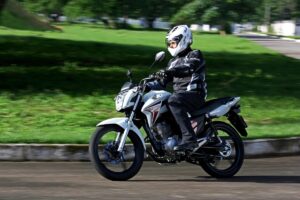 IPVA de motos até 180 cc: O que muda em SP motocicleta urbana de baixa cilindrada em São Paulo, vista frontal 3/4, em circulação no trânsito da cidade