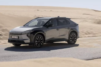 Toyota bZ4X AWD branco, vista frontal 3/4 em estúdio, destacando os faróis afilados e a dianteira fechada de carro elétrico