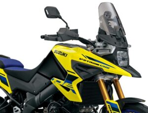 Suzuki V-Strom 1050XT 2027 em estúdio, vista frontal 3/4, cor nova da linha 2027, farol duplo ligado