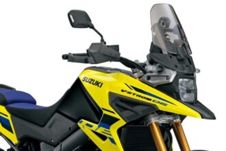 Suzuki V-Strom 1050XT 2027 em estúdio, vista frontal 3/4, cor nova da linha 2027, farol duplo ligado