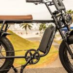 bicicleta elétrica e equipamento autopropelido circulando em ciclovia urbana, com sinalização horizontal e ciclistas ao fundo