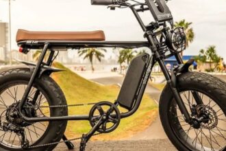 bicicleta elétrica e equipamento autopropelido circulando em ciclovia urbana, com sinalização horizontal e ciclistas ao fundo