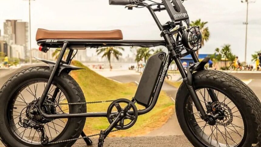 bicicleta elétrica e equipamento autopropelido circulando em ciclovia urbana, com sinalização horizontal e ciclistas ao fundo