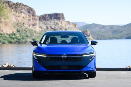 Nissan Sentra 2026 prata, vista frontal 3/4 em ambiente urbano, destaque para faróis de LED e grade dianteira