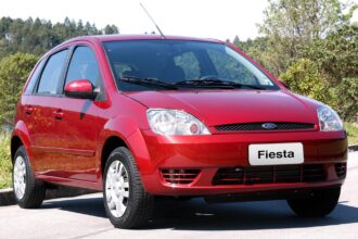 Ford Fiesta 1.0 Rocam prata, vista frontal 3/4 em rua urbana, destaque para hatch compacto e proporções simples