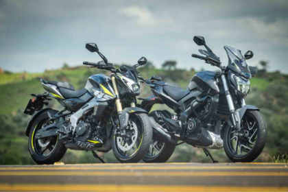 Bajaj Dominar 400 azul escura em vista frontal 3/4, em estúdio, destacando bolha, protetores de mão e postura de sport tourer