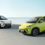 Concessionária BYD Vitória Motors com fachada moderna, carros elétricos expostos na área externa e movimentação de clientes em loja