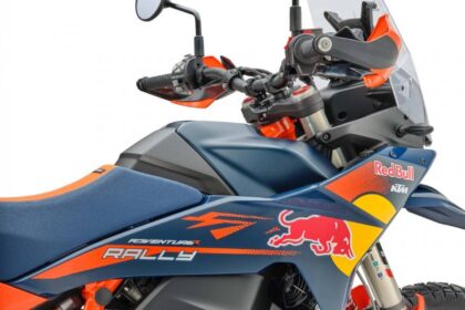 KTM 890 Adventure R Rally 2026 laranja, vista frontal 3/4 em estúdio, com rodas raiadas 21/18 e carenagem alta