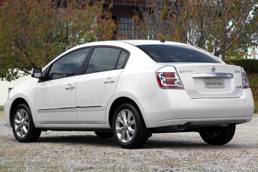 Nissan March 1.0 branco, vista frontal 3/4 em rua urbana, com foco no porte compacto