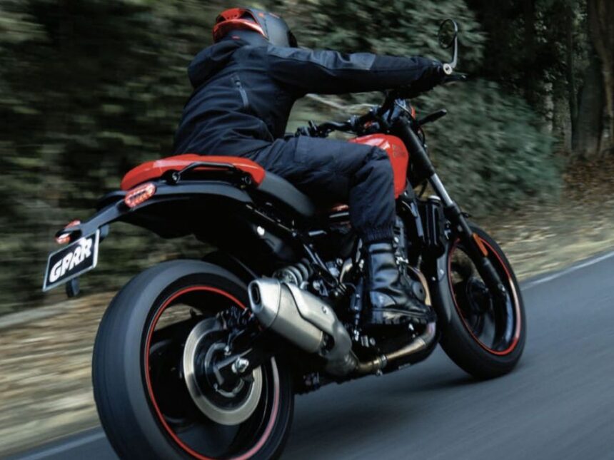 Royal Enfield Guerrilla 450 2026 em vista frontal 3/4, cor escura, foco na nova postura da versão APEX e no farol redondo