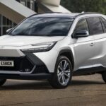 Toyota Corolla Cross atual em vista frontal 3/4, SUV médio prata em estúdio, destacando grade, faróis e altura do capô