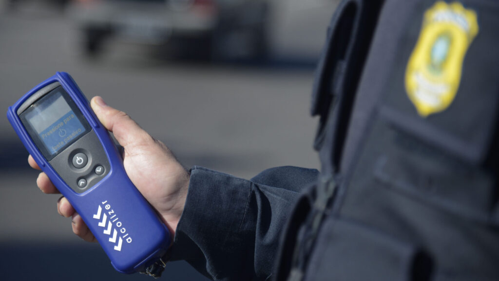Agente da Polícia Rodoviária Federal aplica bafômetro passivo em motorista na praça de pedágio da Ponte Rio-Niterói