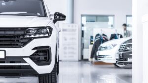Financiamento de carro ainda faz sentido para 62%? casal assinando contrato de financiamento de carro em concessionária brasileira, mesa com chave do veículo e vendedor ao lado, foto horizontal