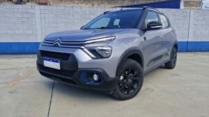 Citroën Basalt Dark Edition Turbo 200 AT em foto frontal horizontal, estacionado em concessionária brasileira com banner de venda direta ao fundo