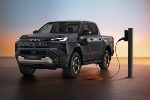Hilux elétrica estreia com foco corporativo no Reino Unido Toyota Hilux elétrica em foto frontal, estacionada em concessionária britânica, cor branca, enquadramento horizontal