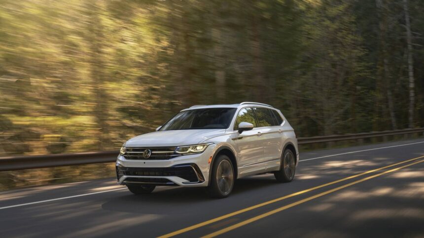 Volkswagen Tiguan prata visto de frente em estacionamento externo, destaque para interior com bancos dianteiros, foto horizontal