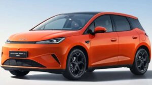 BYD Dolphin G DM-i: Quando estreia o hatch híbrido? BYD Dolphin G DM-i em vista frontal, hatch compacto híbrido plug-in com nova dianteira e faróis finos, foto horizontal em ambiente urbano europeu