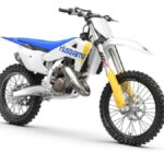 Linha Husqvarna motocross 2027 com carroceria branca, motos TC e FC alinhadas em pista de terra, foto horizontal