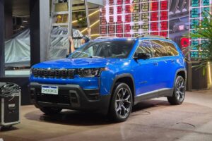 Registro do Cherokee acende disputa entre SUVs premium Jeep Cherokee 2026 híbrido em foto frontal de três quartos, cor escura, parado em estrada asfaltada, landscape
