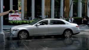 Mercedes-Maybach Classe S preto em vista frontal, parado diante de hotel de luxo à noite, fotografia horizontal