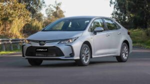 Corolla 2026 pesa no bolso com híbrido acima de R$ 210 mil Toyota Corolla 2026 prata em foto frontal três quartos, estacionado em concessionária brasileira, landscape