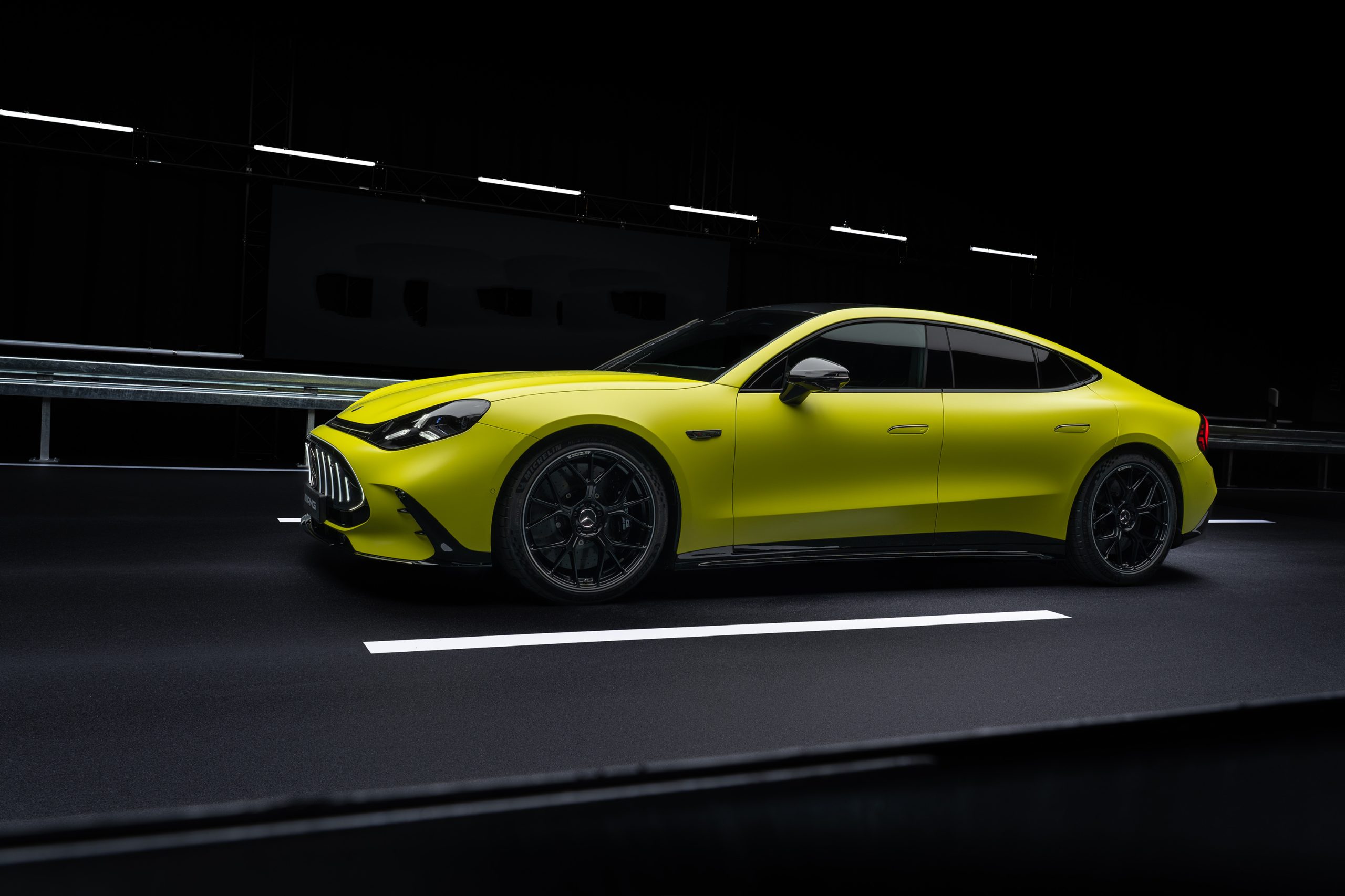 Mercedes-AMG GT 4-Door Coupé elétrico conectado a carregador rápido em estação moderna, vista lateral horizontal
