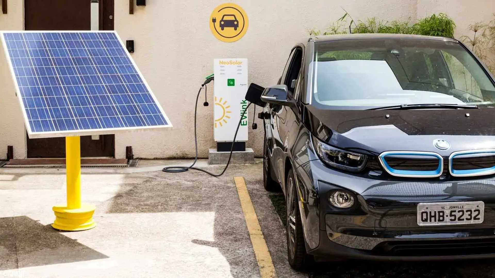 garagem de condomínio com duas vagas equipadas com carregadores de carro elétrico e quadro elétrico ao fundo, imagem horizontal