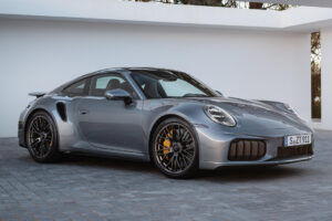 Porsche 911 Turbo S 992.2 T-Hybrid prata em foto frontal três quartos no autódromo Velocitta, landscape